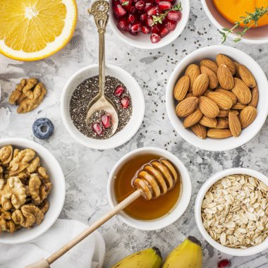 Sağlıklı bir kahvaltı, fındık, yulaf ezmesi, tatlım, meyveler, meyve, yaban mersini, portakal, nar taneleri, badem, ceviz için malzemeler sezonu üst doğal organik gıda kavramı