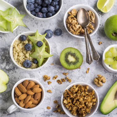 Sağlıklı bir kahvaltı, avokado, quinoa kase, carambola, yeşil elma, muz, kivi, fındık, yulaf ezmesi, meyveler, meyve, yaban mersini, badem, ceviz için malzemeler. Deniz doğal organik gıda kavramı