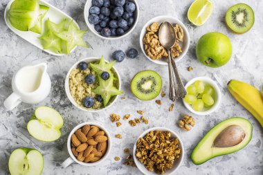 Sağlıklı bir kahvaltı, fındık, yulaf ezmesi, meyveler, meyve, yaban mersini, badem, ceviz için malzemeler sezonu üst doğal organik gıda kavramı görüntüleyin. Yeşillik