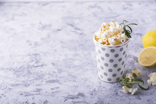 Zoute knapperige verse zelfgemaakte popcorn op smaak gebracht met citroen schil en rozemarijn geur op een eenvoudige houten achtergrond. Het concept van natuurlijke biologische seizoensgebonden voeding — Stockfoto