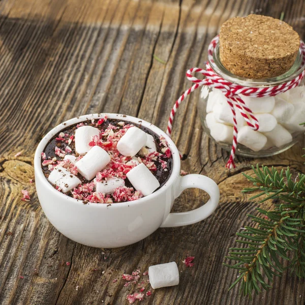Csésze illatos házi kakaót a marshmallows és zúzott piros fehér cukorka feltöltési. Az egyszerű fa szöveges háttérben. szelektív összpontosít — Stock Fotó