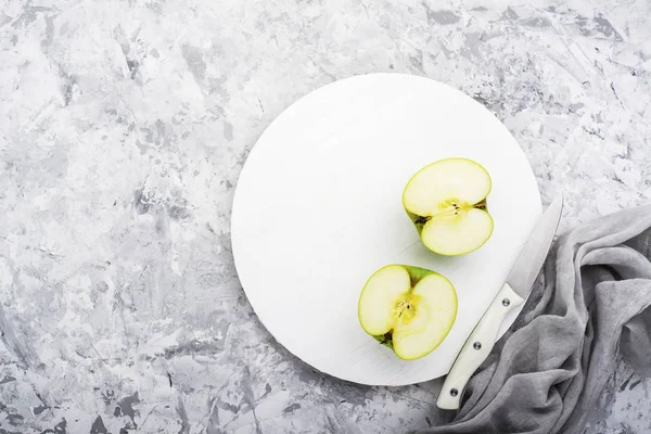 Modieuze kleuren, de groene appels op een grijs marmeren tafel witte snijplank. Bovenaanzicht — Stockfoto