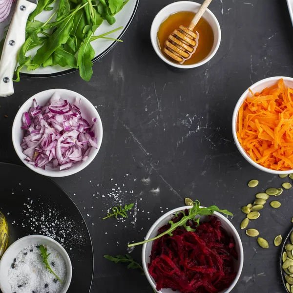 Gezonde vegetarische ingrediënten wortelen, bieten, rode ui, rucola voor frisse salade salades — Stockfoto