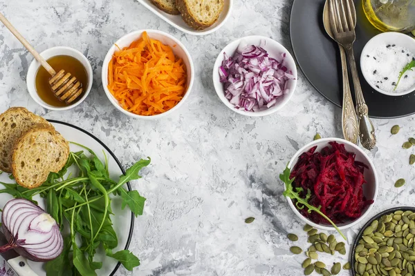 Las verduras de temporada son remolachas, zanahorias, cebolla roja, semillas de calabaza, rúcula para embotellar a la diosa. Vista superior. El concepto de un alimento saludable — Foto de Stock