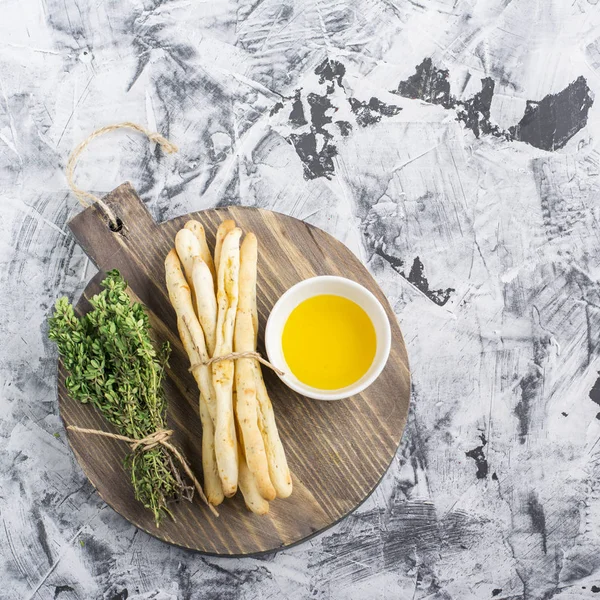 Geurige huisgemaakte knapperig brood sticks met zout en kruiden op donkere houten achtergrond olijfolie, tomaten rozemarijn. Bovenaanzicht — Stockfoto