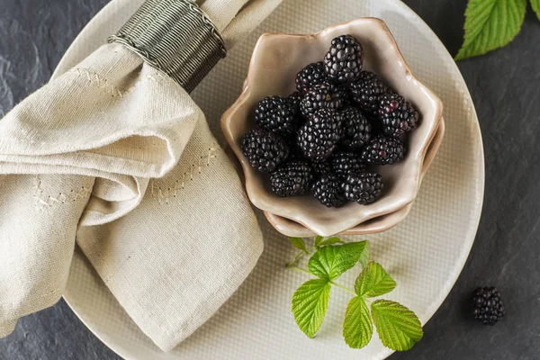 Frische Brombeeren in Portioniertellern aus Keramik auf hellem Holzgrund mit Tischwäsche. Ansicht von oben. Stil-Hygge — Stockfoto