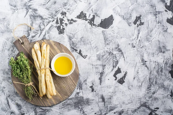 Geurige huisgemaakte knapperig brood sticks met zout en kruiden op donkere houten achtergrond olijfolie, tomaten rozemarijn. Bovenaanzicht — Stockfoto