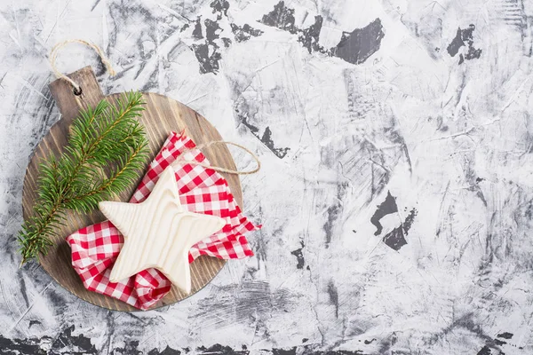 Enkel jul bakgrund med trä styrelsen, star och fir filial på ljus grå marmor. Ovanifrån — Stockfoto