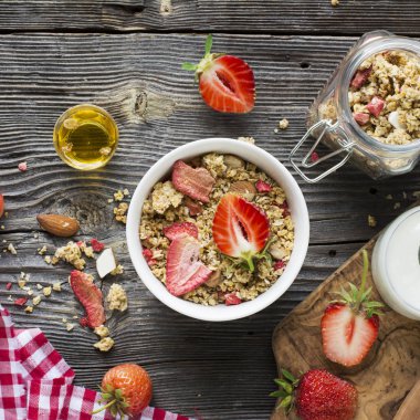 Sağlıklı kahvaltı. Çilek granola badem yaprakları ve taze çilek ile. Süt hizmet, nane canım. Üstten Görünüm