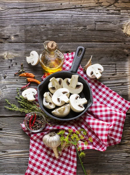 Champiñones, perejil, eneldo, cebolla, aceite de oliva, especias - ingredientes para la preparación de platos de champiñones en una sartén sobre fondo de madera — Foto de Stock