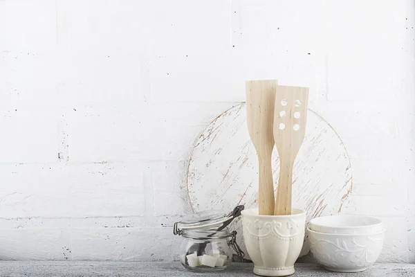 Una cocina sencilla bodegón contra una pared de ladrillo blanco: tabla de cortar, equipo de cocina, cerámica. Horizontal —  Fotos de Stock