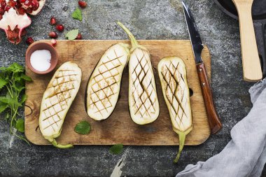 Taze olgun patlıcan bir bıçakla dilimlenmiş ve bir gri granit zemin üzerine bir garnitür için ızgara önce tuz serpilir. Üstten Görünüm.