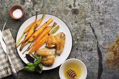 Tatlım sır sarımsaklı havuç pişmiş, zeytin yağı, adaçayı ve sarımsak fesleğen ile öğle yemeği için tavuk kanatlı yaprakları yeşil ve mor. Üstten Görünüm.