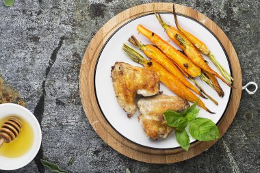 Tatlım sır sarımsaklı havuç pişmiş, zeytin yağı, adaçayı ve sarımsak fesleğen ile öğle yemeği için tavuk kanatlı yaprakları yeşil ve mor. Üstten Görünüm.