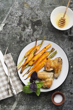 Tatlım sır sarımsaklı havuç pişmiş, zeytin yağı, adaçayı ve sarımsak fesleğen ile öğle yemeği için tavuk kanatlı yaprakları yeşil ve mor. Üstten Görünüm.