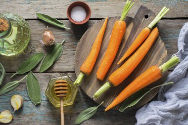 Genç sulu havuç, adaçayı, çiçek bal, sarımsak, tuz malzemeler karamel pişirme için baharatlı havuç. Üstten Görünüm.