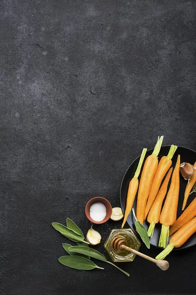 Genç sulu havuç, adaçayı, çiçek bal, sarımsak, tuz malzemeler karamel pişirme için baharatlı havuç. Üstten Görünüm.