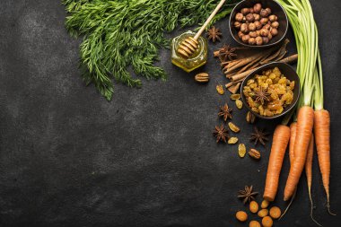 Malzemeler geleneksel klasik havuç için aromalı sonbahar mevsim pasta: sulu taze havuç, Kuru üzüm, baharatlar, baharat, tatlım, karanlık bir arka plan üzerinde fındık. Üstten Görünüm.