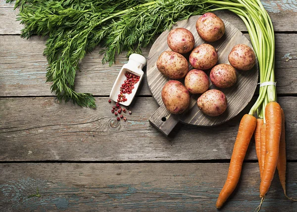 Taze organik tarım sebze: sulu havuç, baharat ve bir bıçak basit bir ahşap zemin üzerine genç patates. Üstten Görünüm.
