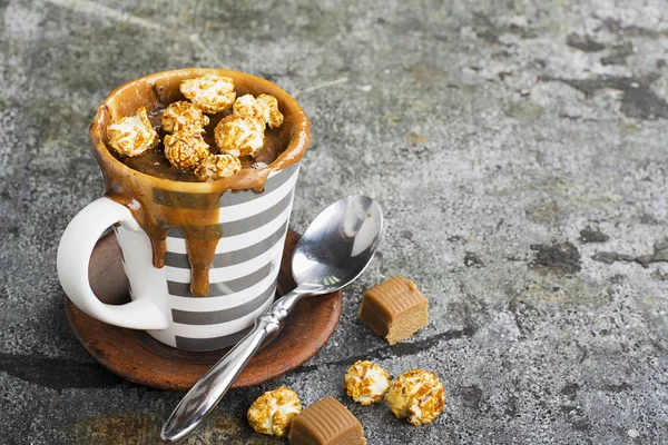 Un mug cupcake au chocolat et caramel salé dans une tasse en céramique rayée grise sur un simple fond gris. Concentration sélective. Snack pendant cinq minutes au micro-ondes . — Photo