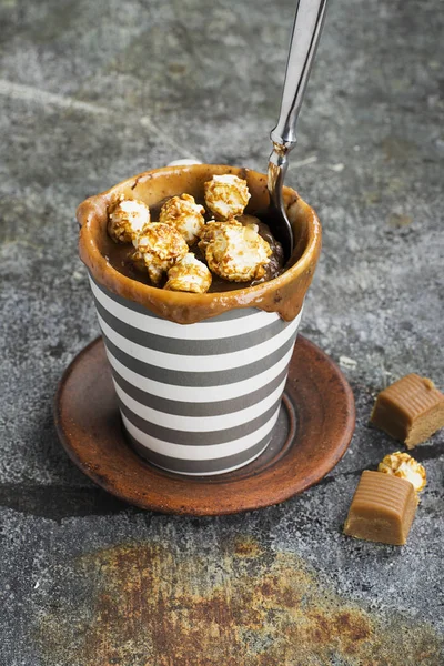 A csokoládé és a sós karamell-egyszerű szürke háttéren egy szürke csíkos kerámia bögre, bögre cupcake. Szelektív összpontosít. A mikrohullámú sütőben 5 percig snack. — Stock Fotó