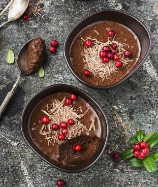 Ev yapımı hassas çikolata mousse kızılcık ve gri taş zemin üzerine seramik kase hizmet içinde çikolata parçaları ile. Üstten Görünüm.