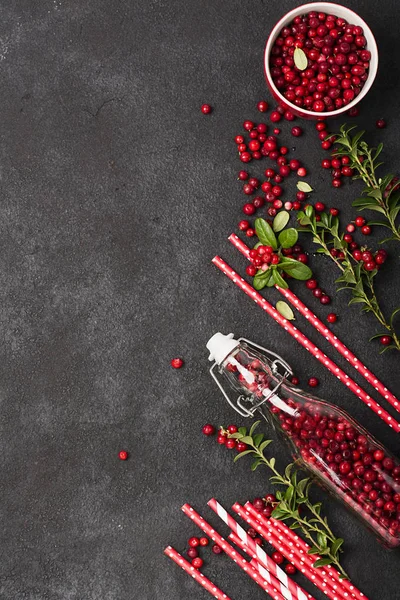 Garrafa cheia de bagas frescas amadurecidas do norte de lingonberry com palhas para um coquetel. O conceito de bebidas saudáveis de produtos orgânicos. Vista superior . — Fotografia de Stock