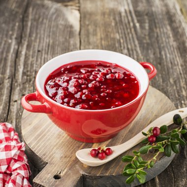 Mükemmel aperatifler ve ana yemekler için baharat. Taze ev yapımı baharatlı tatlı sos Kuzey ormandan gelen kızılcık hizmet et, peynir için oyun için bir arka plan üzerine bir kase çilek. Üstten Görünüm.