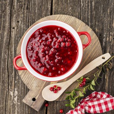 Mükemmel aperatifler ve ana yemekler için baharat. Taze ev yapımı baharatlı tatlı sos Kuzey ormandan gelen kızılcık hizmet et, peynir için oyun için bir arka plan üzerine bir kase çilek. Üstten Görünüm.