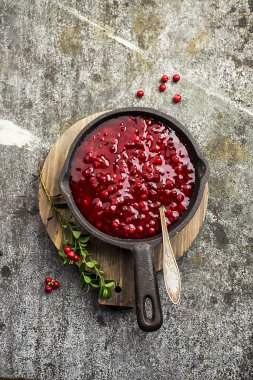 Mükemmel aperatifler ve ana yemekler için baharat. Taze ev yapımı baharatlı tatlı sos Kuzey ormandan gelen kızılcık hizmet et, peynir için oyun için bir arka plan üzerine bir kase çilek. Üstten Görünüm.