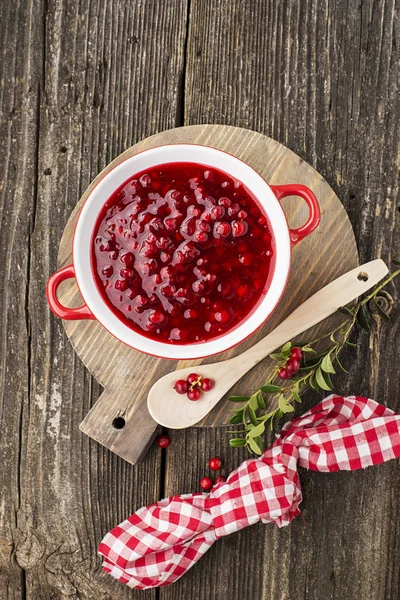 Excellent seasoning for snacks and main dishes. Fresh home made spicy sweet sauce from northern forest berries cranberries in a bowl on a background for serving to meat, to game, to cheeses. Top View. — Stock Photo, Image