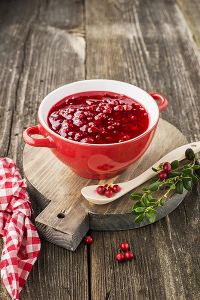 Uitstekende kruiden voor snacks en hoofdgerechten. Verse huisgemaakte pittige zoete saus uit noordelijke bos bessen veenbessen in een kom op een achtergrond voor portie vlees, aan spel, voor kaas. Bovenaanzicht. — Stockfoto