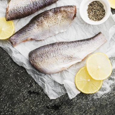 Taze kesilmiş nehir balığı pişirme tuz, biber, limon dilimleri gri grunge arka plan üzerinde daha önce bitti. Üstten Görünüm.