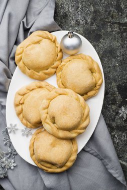 Bütün aile için rahat yemek. Mevsim meyveleri ile taze basit hamur yapılmış ev yapımı mini pies bal ile servis. Gri grunge arka plan üzerinde Üstten Görünüm.