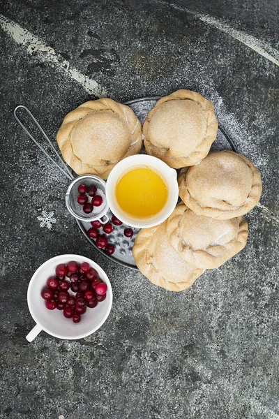 Bequemes Essen für die ganze Familie. hausgemachte Mini-Kuchen aus frischem einfachen Teig mit saisonalen Beeren, serviert mit Honig. Draufsicht auf grauem Grunge-Hintergrund. — Stockfoto