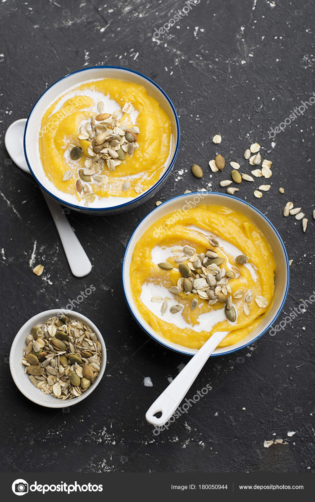 Pumpkin And Apple Cider Soup With A Topping Of Crispy Toasted Pumpkin Seeds Sunflower Seeds And Oat Flakes Purple Basil In A Serving Bowl On A Light Background Top View Stock Photo
