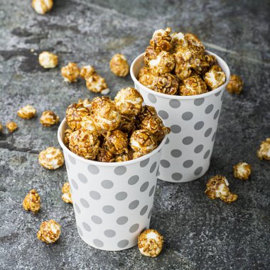 Patlamış mısır kağıt gri beyaz Noel CUPS ile sokulgan ile yeni yıl Noel dekor, kış tatil toplantılar için bir gri grunge arka plan üzerinde yıldız. Üstten Görünüm.