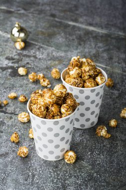 Patlamış mısır kağıt gri beyaz Noel CUPS ile sokulgan ile yeni yıl Noel dekor, kış tatil toplantılar için bir gri grunge arka plan üzerinde yıldız. Üstten Görünüm.