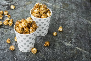 Patlamış mısır kağıt gri beyaz Noel CUPS ile sokulgan ile yeni yıl Noel dekor, kış tatil toplantılar için bir gri grunge arka plan üzerinde yıldız. Üstten Görünüm.