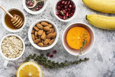 Sağlıklı bir kahvaltı, fındık, yulaf ezmesi, tatlım, meyveler, meyve, yaban mersini, portakal, nar taneleri, badem, ceviz için malzemeler sezonu doğal organik gıda kavramı. Üstten Görünüm