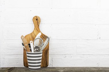 Mutfak araçları, zeytin kesme tahtası beyaz duvara karşı bir mutfak raf. seçici odak