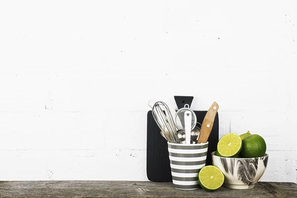 Bir basit mutfak natürmort beyaz tuğla duvar yemekleri modern trendy renkler gri, siyah, beyaz taze parlak limes ile karşı. Yatay. Seçici odak, — Stok fotoğraf