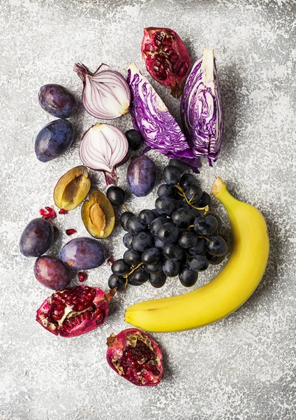 Legumes e frutas ricas em vitamina antocianina: bananas, mirtilos, repolho vermelho, cebolas roxas doces, uvas escuras, ameixas. Benefícios da nutrição para o coração e sistema cardiovascular. Vista superior . — Fotografia de Stock