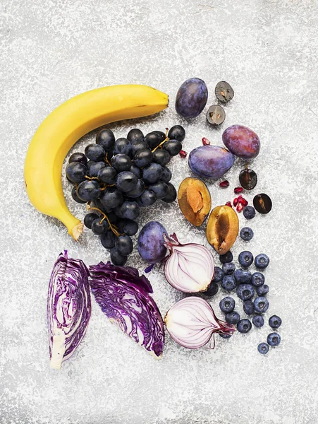 Овощи и фрукты, богатые витаминным антоцианином: бананы, черника, красная капуста, сладкий фиолетовый лук, темный виноград, чернослив. Преимущества питания для сердца и сердечно-сосудистой системы. Вид сверху . — стоковое фото