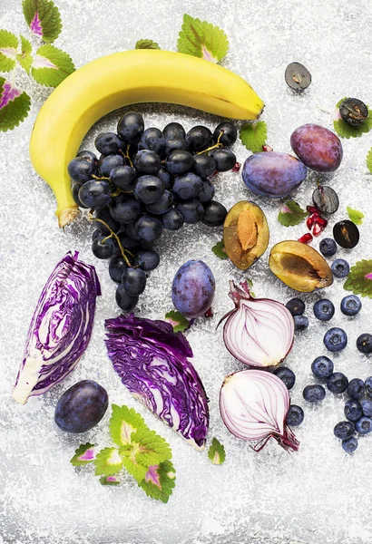 Groenten en fruit rijk is aan vitamine anthocyanin: bananen, bosbessen, rode kool, zoete paarse uien, donkere druiven, pruimen. Voordelen van voeding voor het hart en vaatstelsel. Bovenaanzicht. — Stockfoto