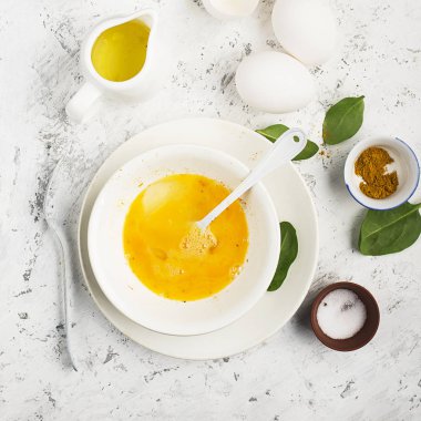 Ispanak ve zerdeçal arka planda ile çırpılmış yumurta için malzemeler. Üstten Görünüm. Kopya alanı.