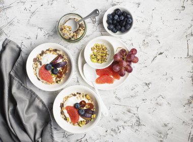 Mevsimlik sağlıklı kahvaltı: yoğurt, çikolata granola, Pembe greyfurt, üzüm, fıstık. Üstten Görünüm. Uzay kopyalayın. düz lay