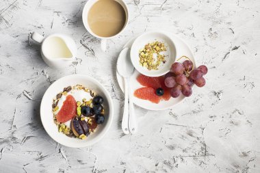 Mevsimlik sağlıklı kahvaltı: yoğurt, çikolata granola, Pembe greyfurt, üzüm, fıstık. Üstten Görünüm. Uzay kopyalayın. düz lay