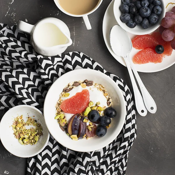 Desayuno saludable de temporada: yogur, granola de chocolate, pomelo rosa, uvas, pistachos. Vista superior. Copiar espacio. plano laico — Foto de Stock