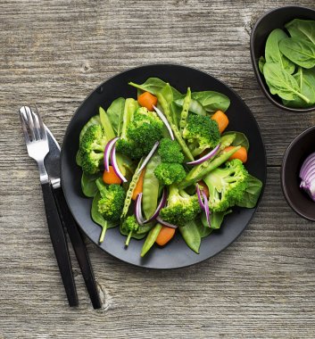 Vejetaryen yemek aperatif brokoli, genç bezelye, bebek havuç, çam fıstığı ile tatlı soğan salatası. Üstten Görünüm.